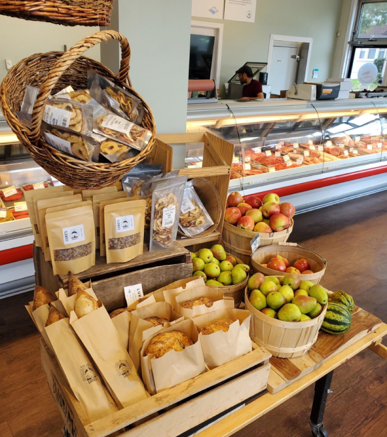 Interior of Osprey's Roost with showcase of bread, fruits and groceries in front of the meat counter
